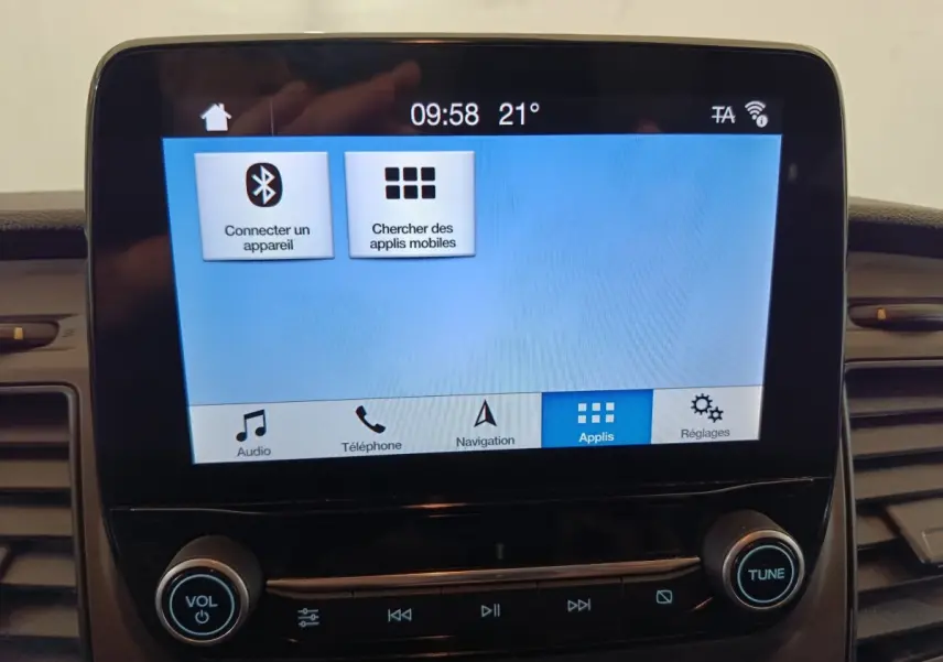 Écran tactile central du Ford Transit Custom blanc, affichant le menu Bluetooth et applications, vue intérieure frontale.