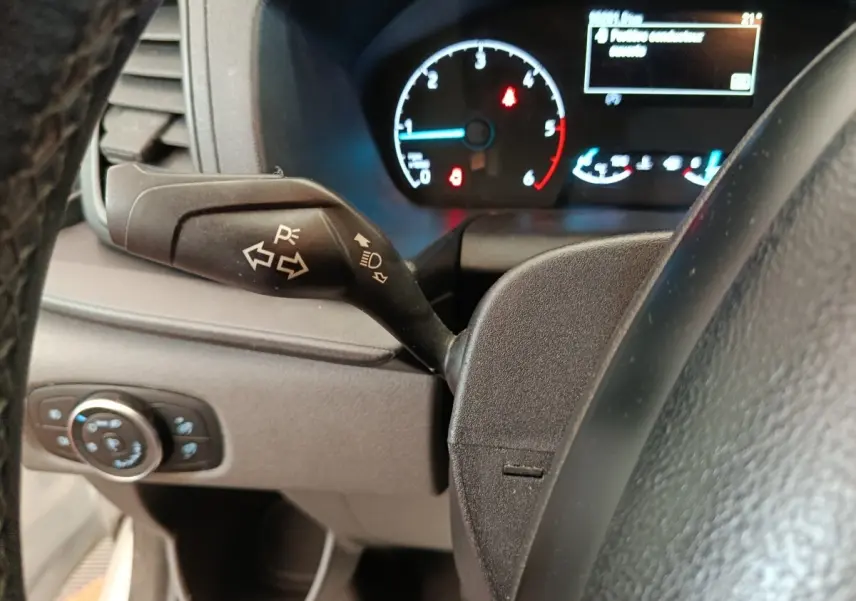 Vue rapprochée du commodo de clignotant à gauche sur le tableau de bord noir du Ford Transit Custom 2020.