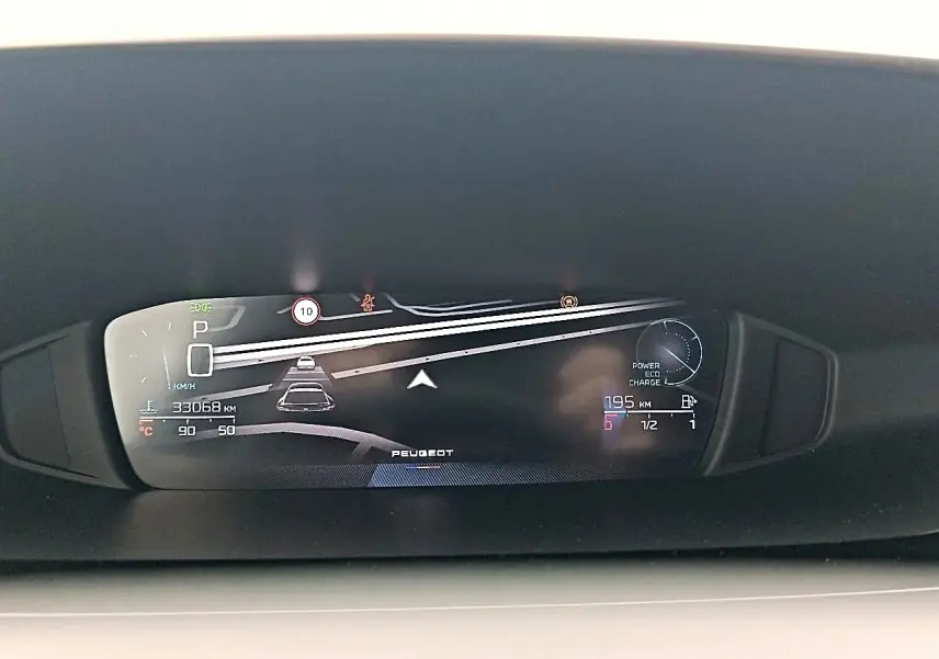 Affichage numérique du tableau de bord de la Peugeot 408 Hybrid 145 allure, montrant la vitesse, autonomie et alertes.