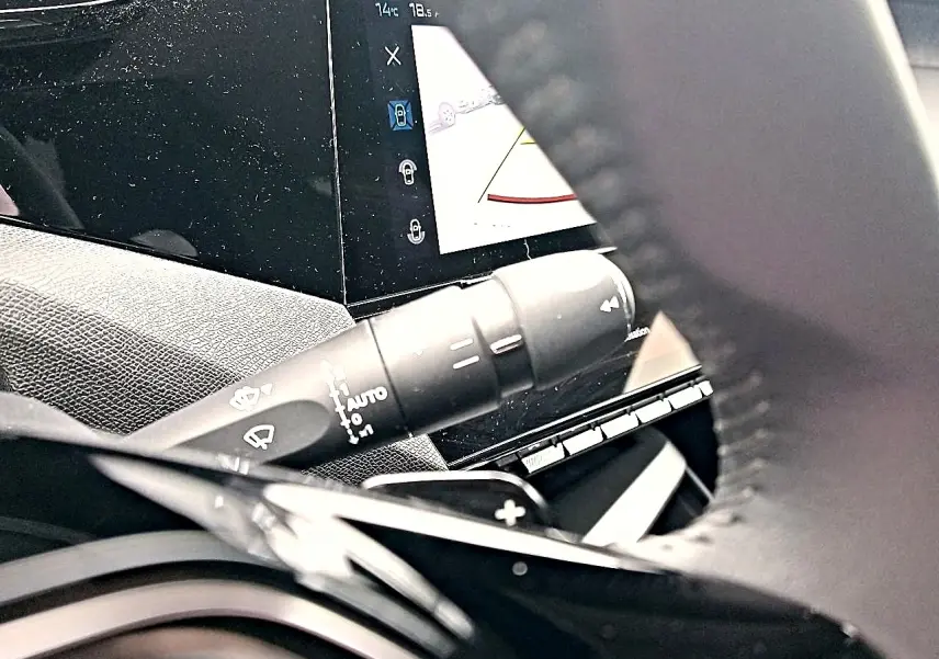 Gros plan sur la commande d’essuie-glace et l’écran tactile du tableau de bord d’une Peugeot 408 gris sélénite.