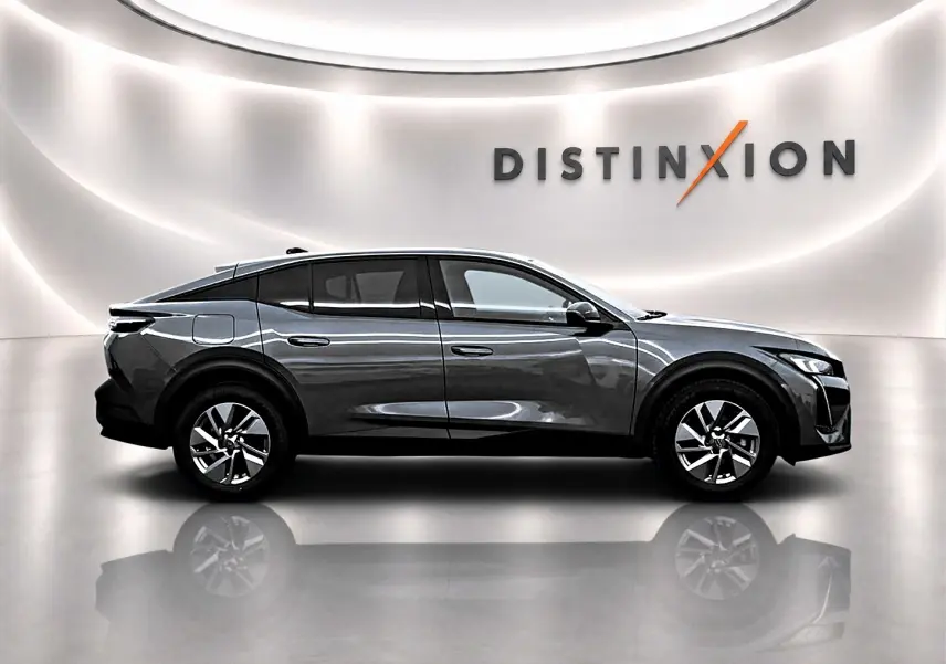 Profil droit du Peugeot 408 Hybrid 145 allure gris sellenium e avec jantes alu et toit noir dans un studio lumineux.