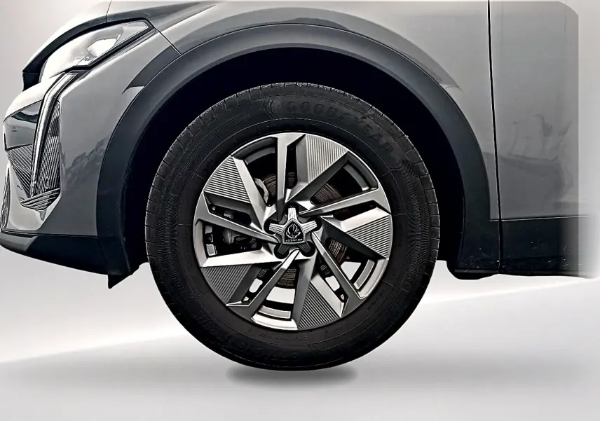 Gros plan sur la roue avant gauche de la Peugeot 408 Hybrid 145 allure gris sélénite avec jante alu au design moderne.
