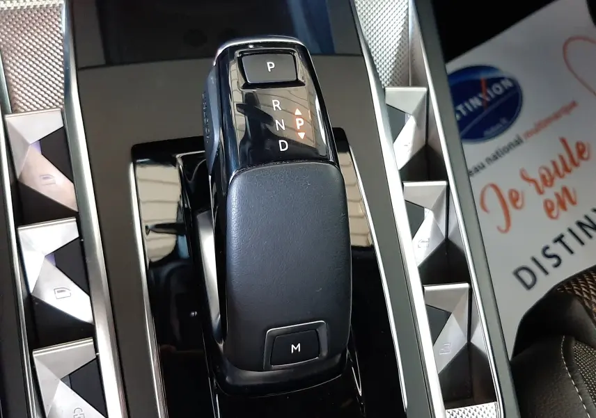 Le levier de vitesses automatique noir du DS3 Crossback 2020, entouré de boutons triangulaires argentés sur la console centrale.