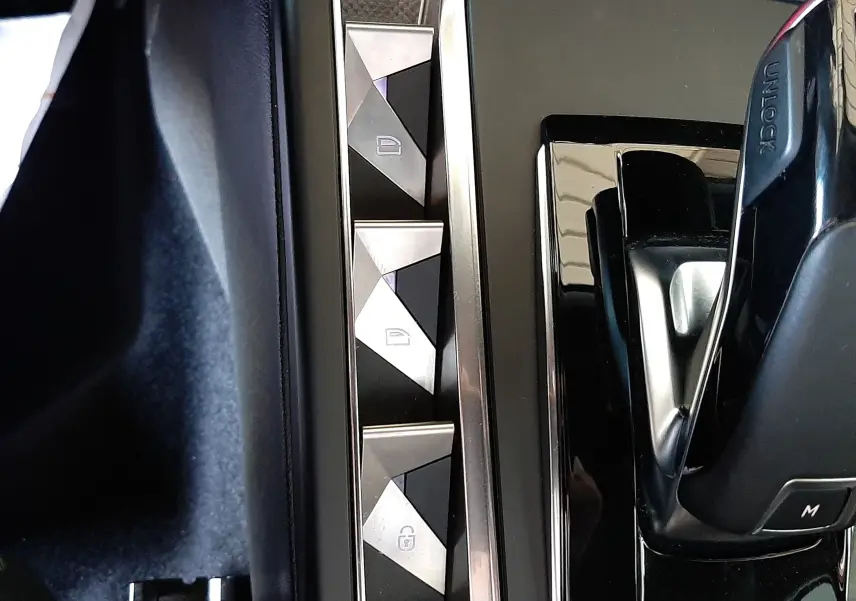 Gros plan sur la console centrale de la DS3 Crossback 2020, avec levier de vitesse et boutons de verrouillage aux formes géométriques.
