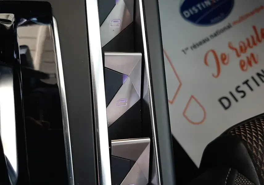Gros plan sur les commandes des vitres électriques triangulaires du DS3 Crossback 2020, finition cuir noir.
