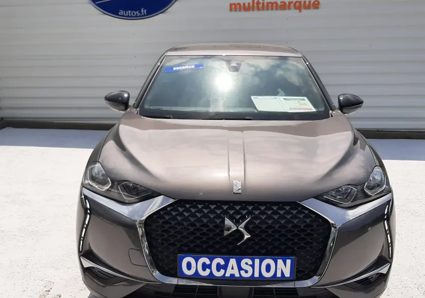 Vue frontale d'une DS3 Crossback gris platinium métal avec calandre noire et phares LED, affichant un panneau "OCCASION".