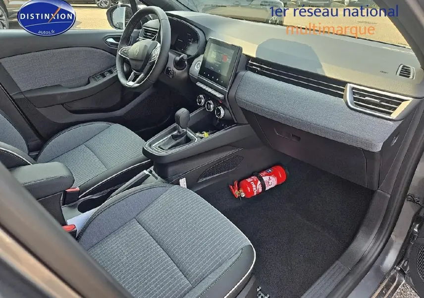 Intérieur avant droit de Renault Clio V gris schiste, montrant siège, volant multifonction et console centrale.
