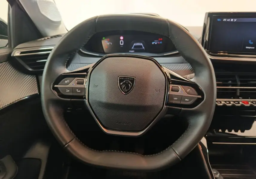 Volant cuir noir de Peugeot 208 PureTech 100 S&S Allure 2025 vu de face avec tableau de bord numérique et écran tactile central.
