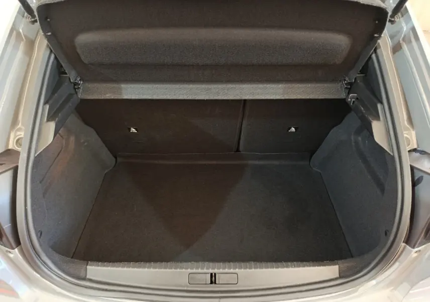 Coffre ouvert vu de dessus d'une Peugeot 208 gris foncé, montrant un espace de chargement propre et spacieux.