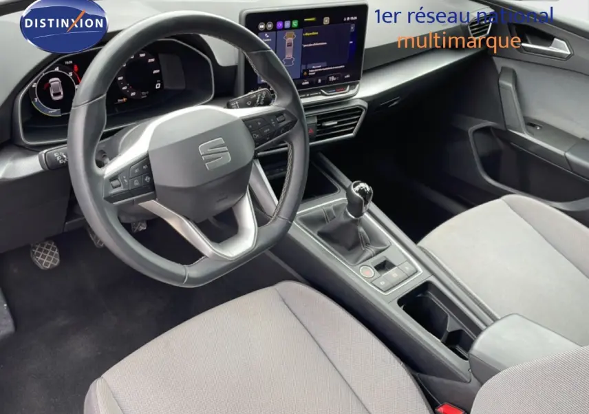Vue intérieure côté conducteur du SEAT LEON ST 2025, volant cuir multifonction et écran tactile central.
