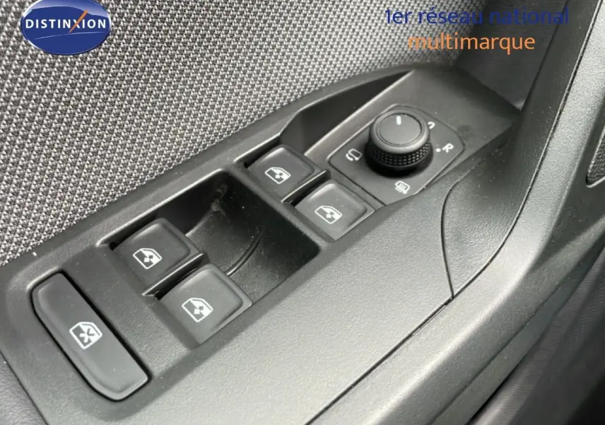 Gros plan sur les commandes des vitres et rétroviseurs côté conducteur du SEAT LEON ST bleu Fjord 2025.