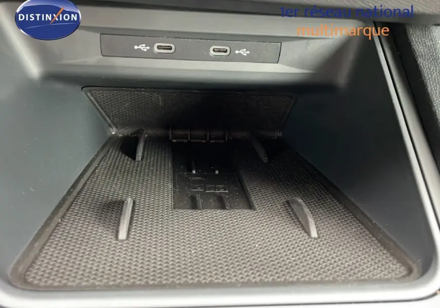Gros plan sur la zone de recharge sans fil et ports USB-C du SEAT LEON ST bleu Fjord, intérieur gris noir.