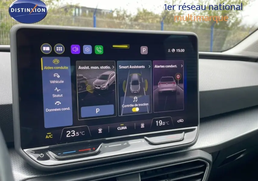 Écran tactile central du tableau de bord du SEAT LEON ST 2025 avec interface d’aides à la conduite et climatisation.