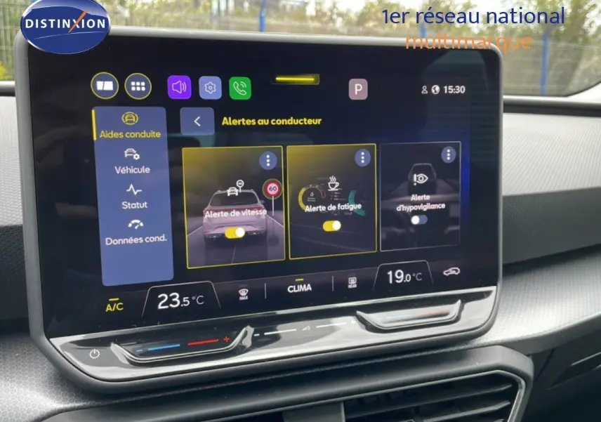 Écran tactile central affichant les alertes au conducteur dans l'habitacle d'une SEAT LEON ST bleu Fjord.