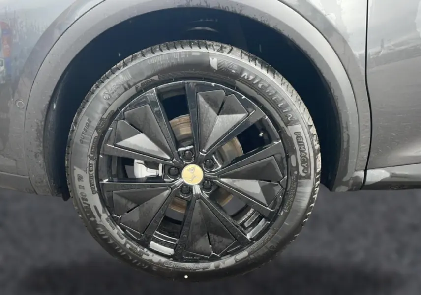 Gros plan sur la jante alu noire au design géométrique du côté gauche d’un DS7 gris titane 2026.