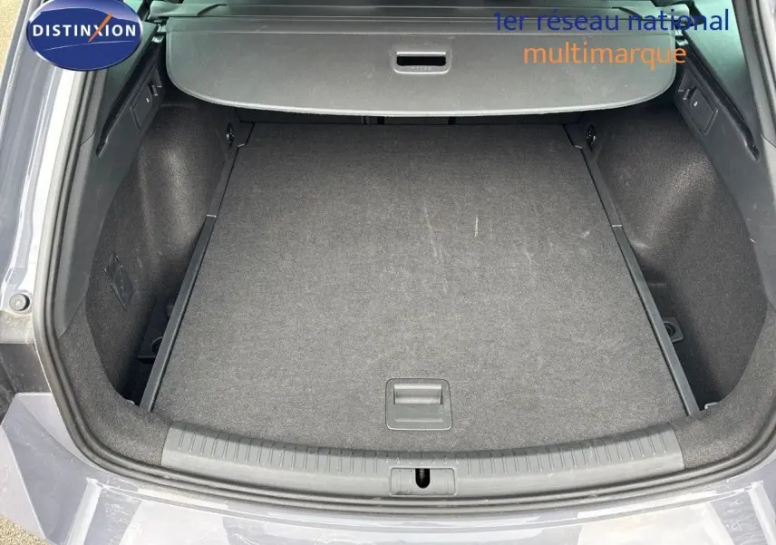 Coffre ouvert en vue arrière d'une CUPRA LEON ST 1.5 ETSI 150CH DSG gris Graphene, montrant l'espace de chargement vide.