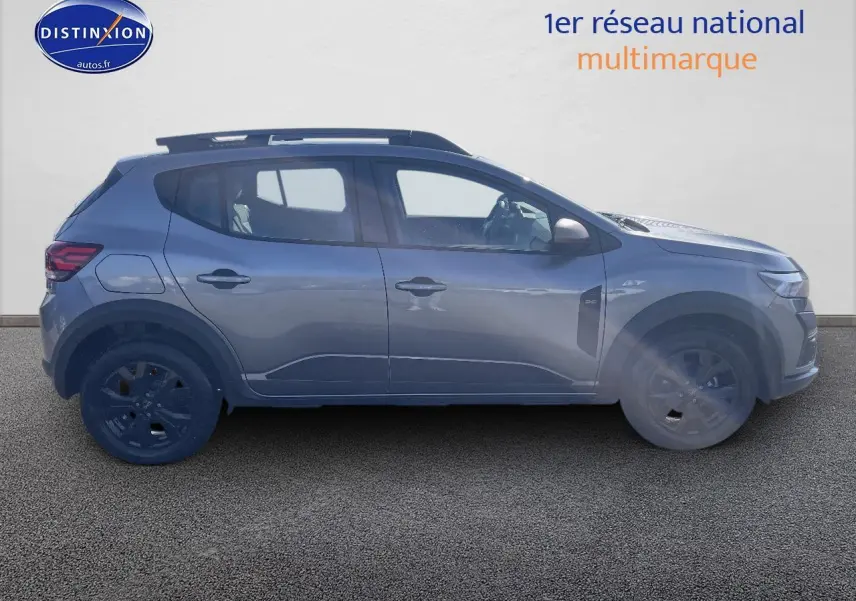 Profil côté gauche d'une Dacia Sandero Stepway gris schiste 2025 avec barres de toit et jantes alu noires.