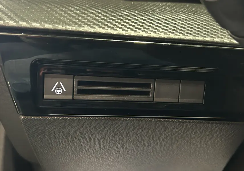 Bouton d'assistance au maintien de voie sur la planche de bord noire du Peugeot 508 SW 2024 intérieur.