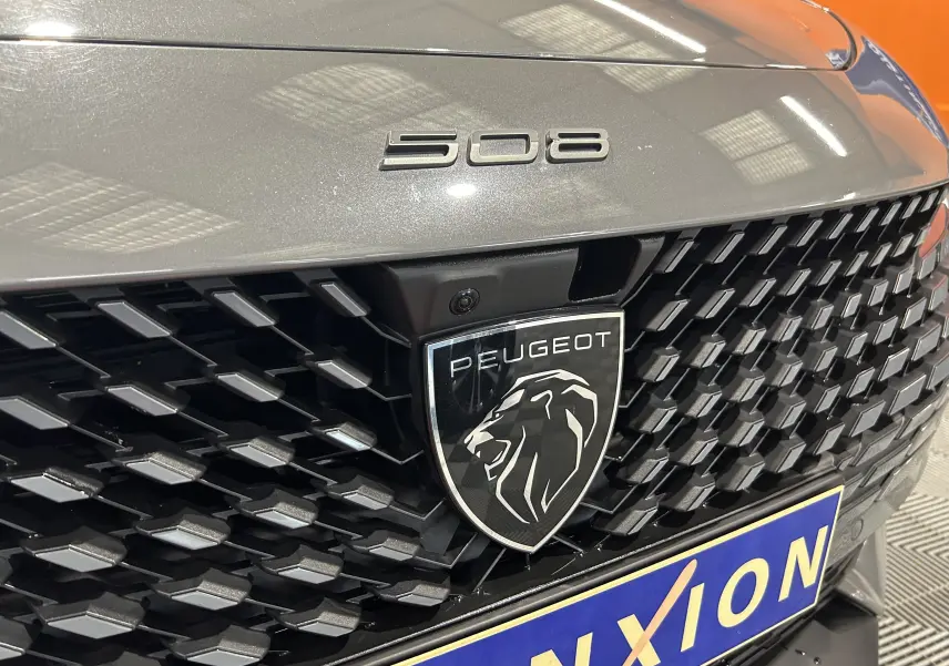 Gros plan sur la calandre avant gris Selenium du Peugeot 508 SW avec logo lion et badge 508 visible.