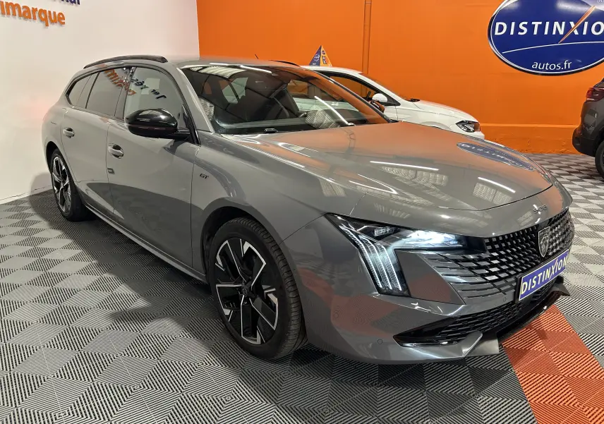 Peugeot 508 SW gris Selenium vue 3/4 avant droit, feux LED allumés et jantes alliage distinctives.