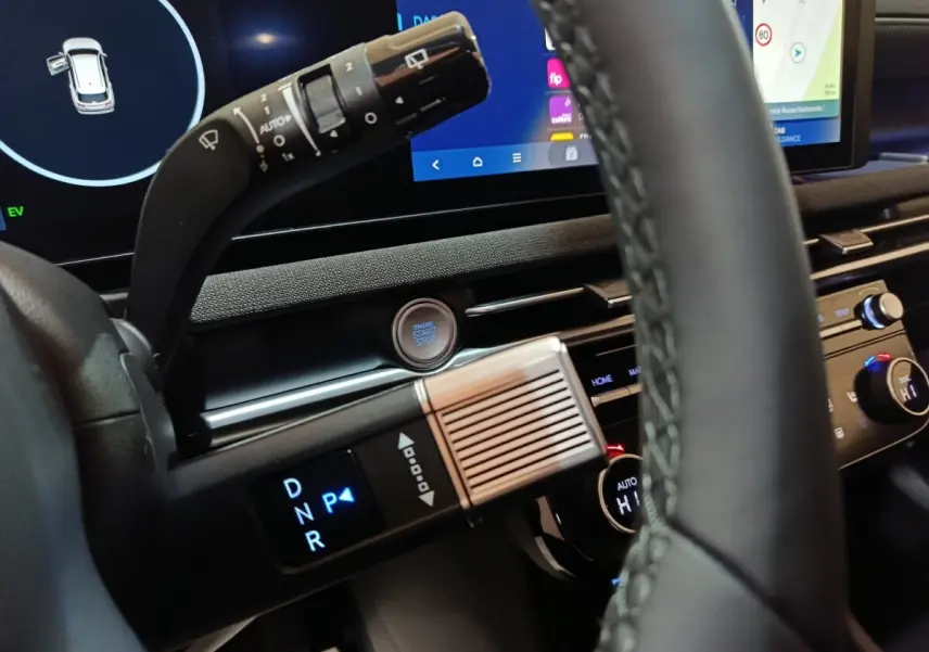 Gros plan intérieur sur la commande de boîte automatique et le tableau de bord numérique du Hyundai Tucson gris clair 2025.