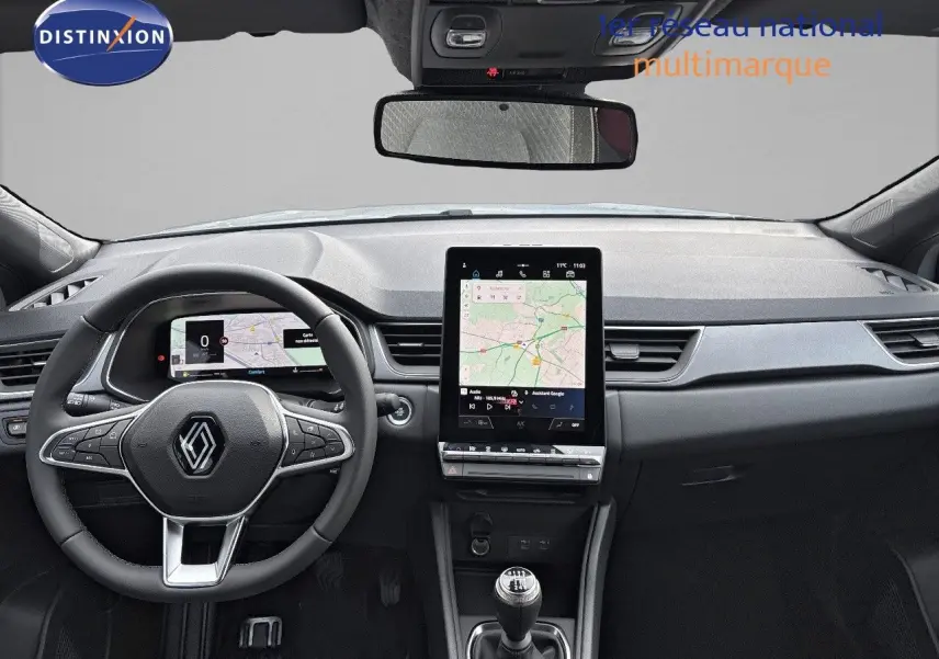 Vue intérieure frontale du tableau de bord du Renault Captur II hybride, avec écran tactile vertical et volant multifonction.