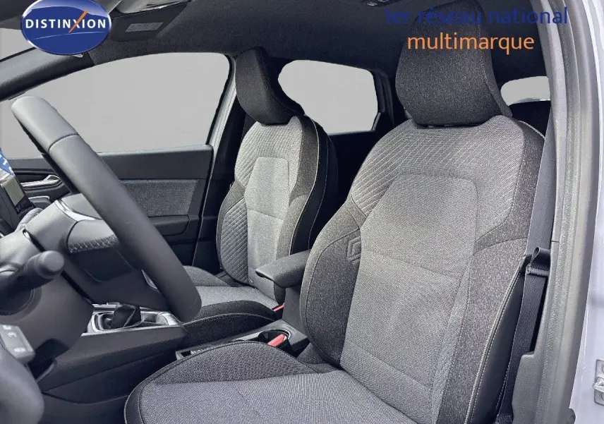 Vue intérieure côté gauche du Renault Captur II 1.6 E-Tech hybride 2025, sièges tissu gris avec accoudoir central.