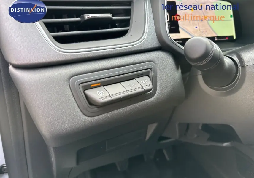 Gros plan sur les commandes à gauche du volant du Renault Captur gris Rafale métal avec écran tactile affichant la navigation.