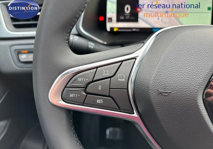 Gros plan sur le volant gris noir du Renault Captur 2025, mettant en valeur les commandes de régulateur de vitesse.