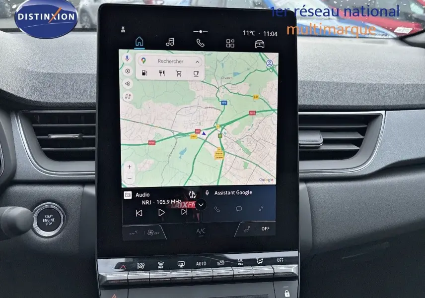 Vue intérieure centrée sur l'écran tactile vertical du tableau de bord du Renault Captur gris Rafale 2025 avec toit noir.