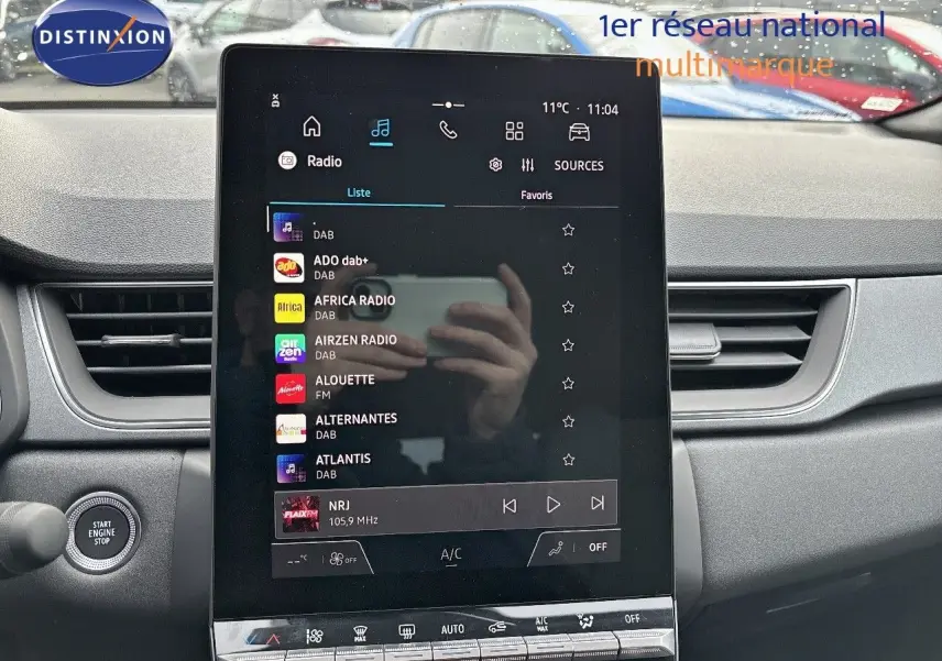 Vue intérieure centrée sur l'écran tactile du tableau de bord du Renault Captur II gris Rafale métal avec toit noir.