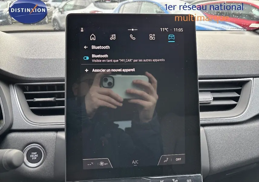 Vue intérieure centrée sur l'écran tactile du tableau de bord du Renault Captur gris rafale métal avec toit noir.