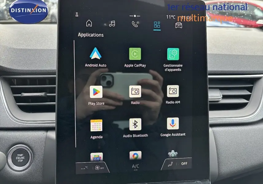 Vue intérieure centrée sur l’écran tactile multimédia du Renault Captur gris Rafale métal avec toit noir.