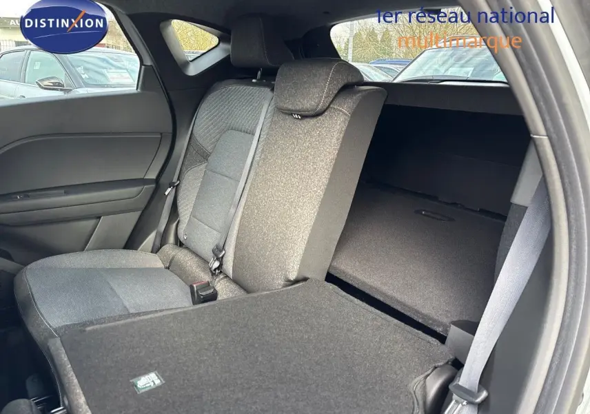 Vue intérieure côté gauche du Renault Captur II hybride 2025, siège arrière rabattable et tissu gris foncé.
