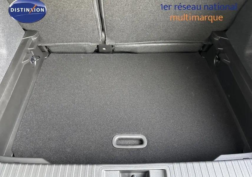 Coffre ouvert vu de dessus d’un Renault Captur II gris Rafale métal avec toit noir, montrant le plancher plat et les sièges arrière rabattus.