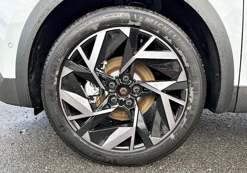 Gros plan sur la roue avant gauche avec jante alu noire et argent du Renault Symbioz gris rafale.