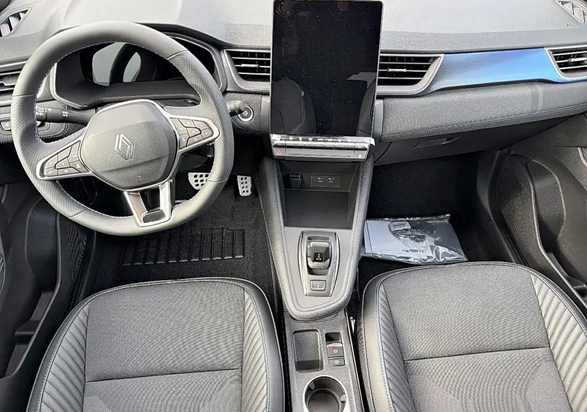 Vue intérieure avant du Renault Symbioz gris rafale, avec volant multifonction, écran tactile vertical et sièges tissu gris.