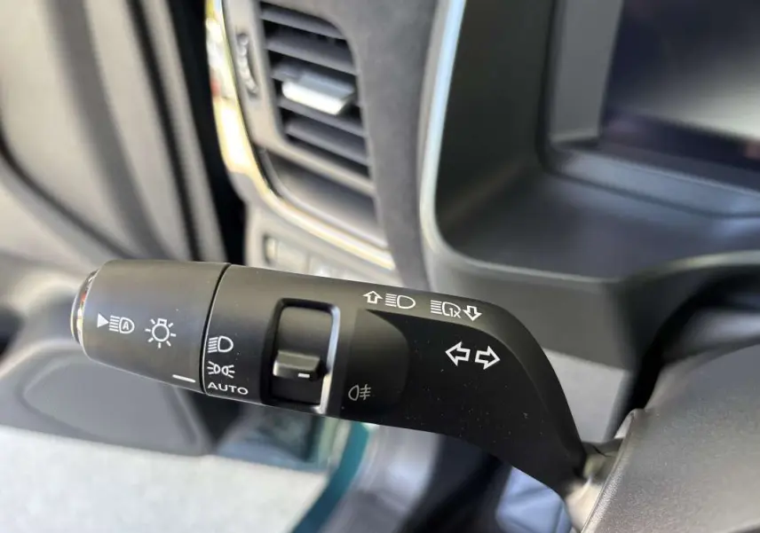 Gros plan sur la commande des feux et clignotants du Nissan Qashqai E-POWER 205 N-DESIGN, intérieur noir.