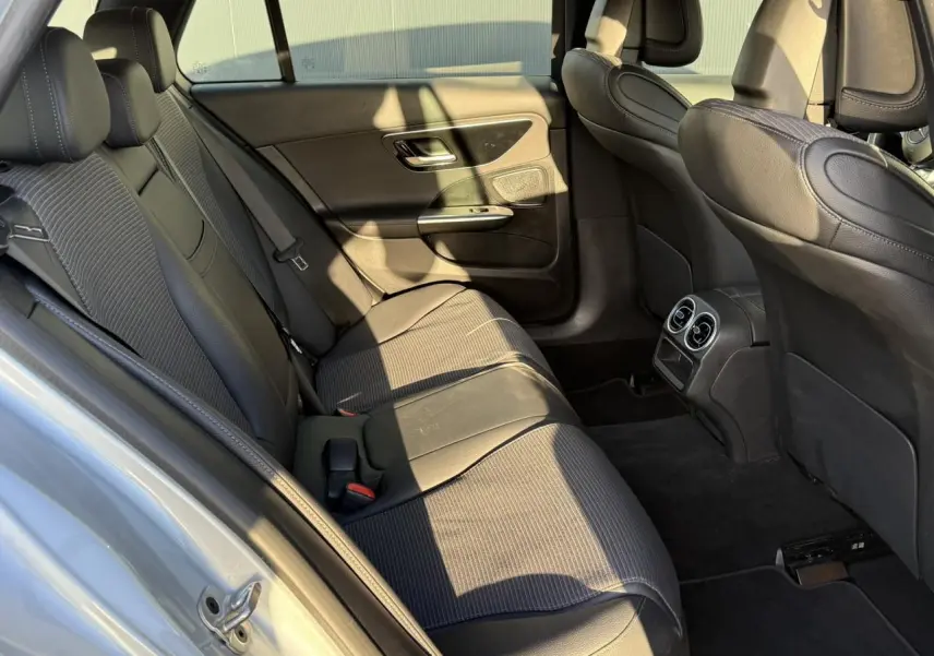 Vue intérieure arrière montrant les sièges noirs en cuir et tissu de la Mercedes Classe C Break 2023.