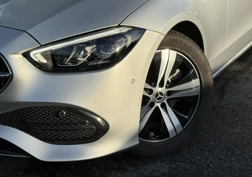 Vue 3/4 arrière droite d'un break Mercedes Classe C argent High-Tech avec feux LED et double sortie d'échappement chromée.