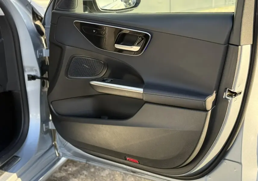 Intérieur noir du Mercedes Classe C Break 2023, vue côté conducteur avec écran tactile vertical et volant multifonction.