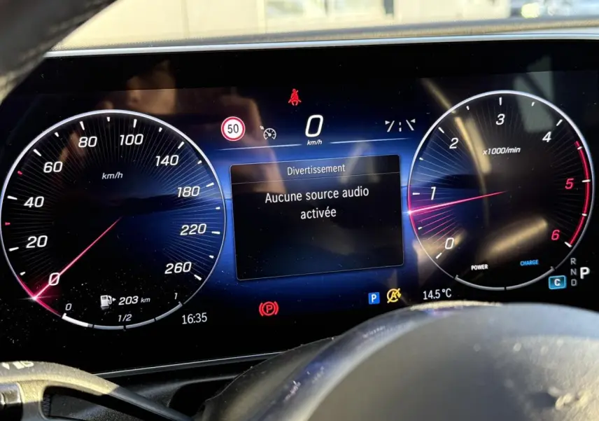 Détail de la porte côté gauche intérieure d'une Mercedes Classe C Break argent, avec poignée alu et bouton de siège chauffant.