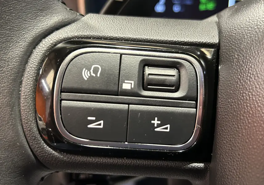 Gros plan sur les commandes de régulateur adaptatif au volant du Citroën C5 Aircross Ph.2 noir Perla Nera 2024.