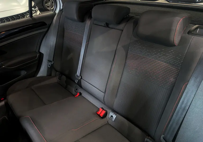 Vue intérieure des sièges arrière en tissu noir avec surpiqûres rouges d'une Volkswagen Golf VII TSI 125 CH Sound 2018.