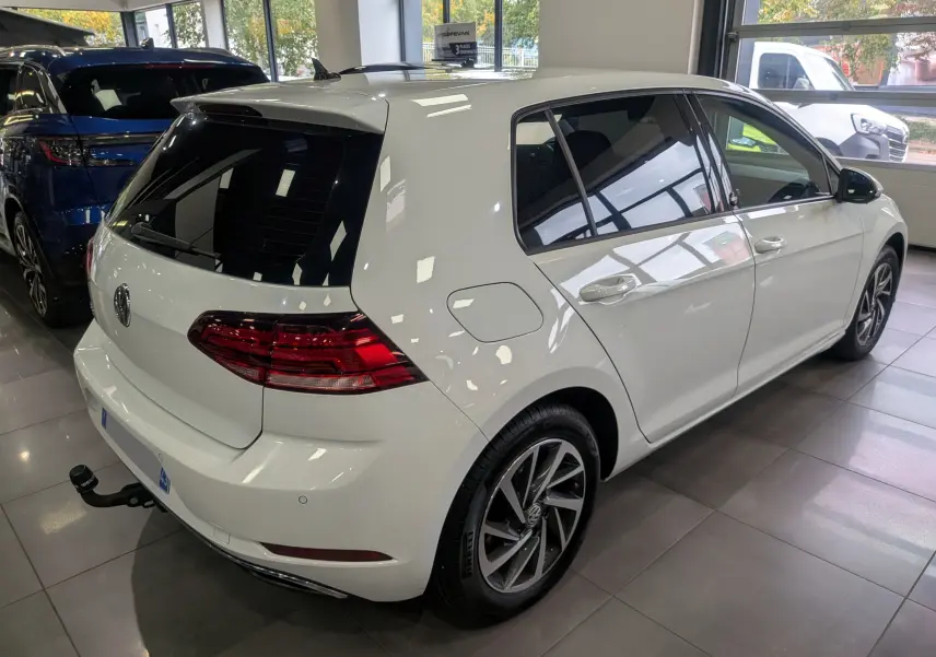 Volkswagen Golf VII TSI 125 ch Sound blanc pur vue 3/4 arrière droit avec attelage en intérieur showroom.