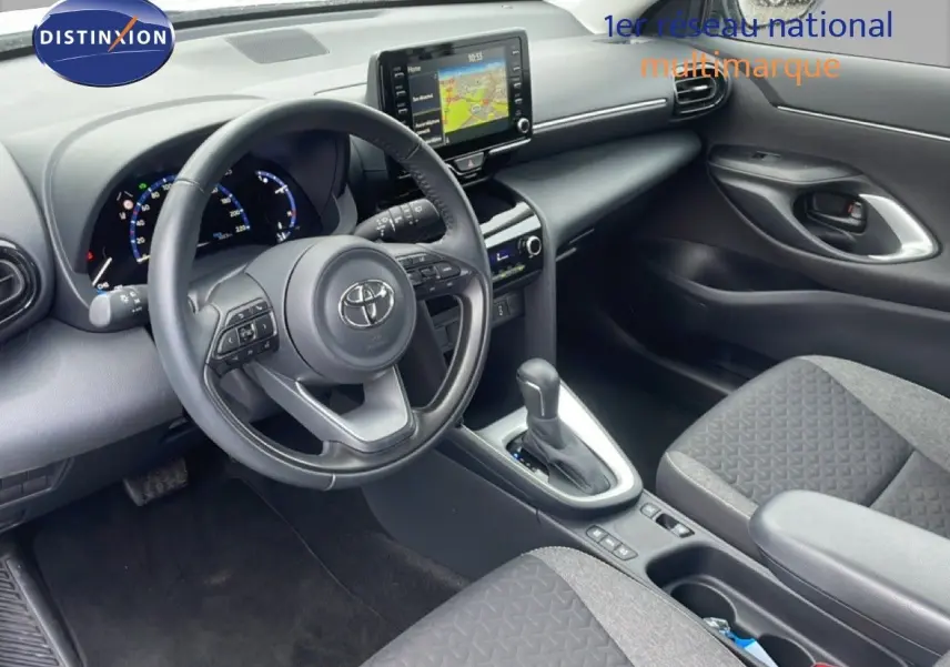 Vue intérieure côté conducteur de la Toyota Yaris Cross Hybrid 117ch Business 2024, tableau de bord et console centrale noirs.