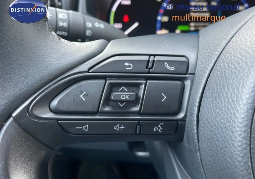Gros plan sur les commandes multifonctions à gauche du volant de la Toyota Yaris Cross Hybrid blanche de 2024.