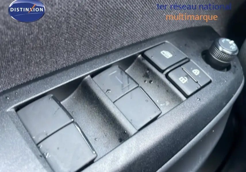 Gros plan sur les commandes de lève-vitres et rétroviseurs côté conducteur d'une Toyota Yaris Cross blanche.