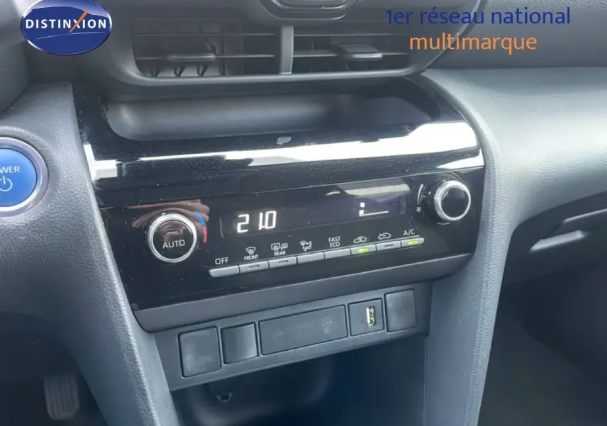 Vue rapprochée du tableau de bord noir de la Toyota Yaris Cross Hybrid 2024, avec commandes climatisation digitales.