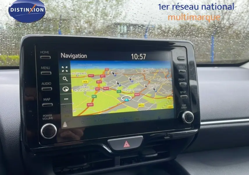 Écran tactile de navigation allumé dans l’habitacle d’une Toyota Yaris Cross blanche, vue de face.